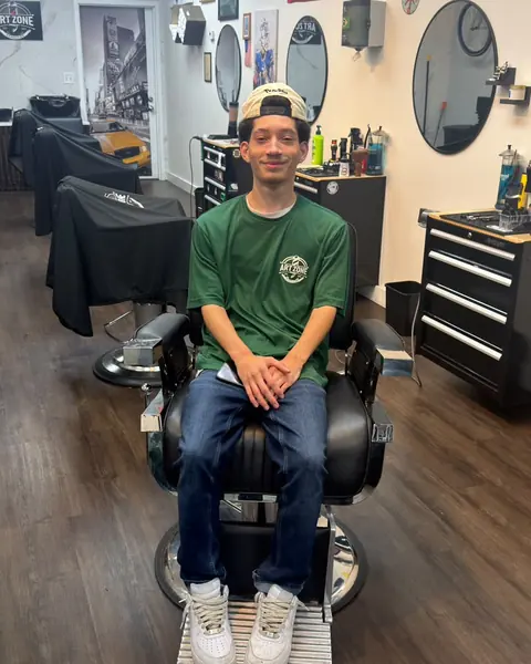 Nate, barber at Art Zone, sitting in a barber chair